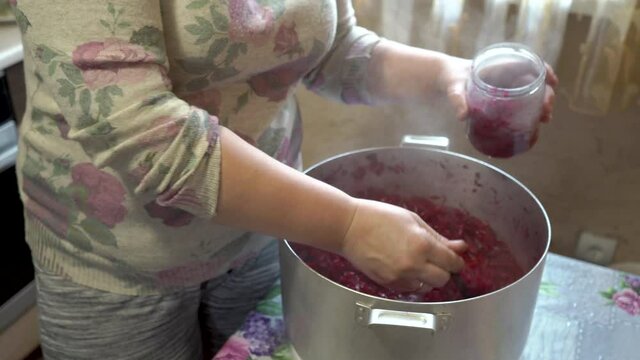 home canning of vegetables,woman in the kitchen puts in jars beets for borscht