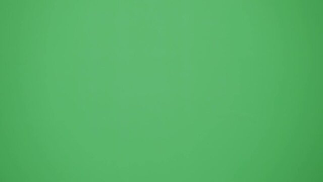 映画撮影のカチンコを鳴らす手元（クロマキー合成・緑背景）