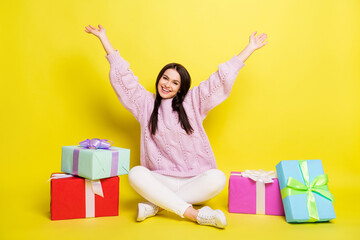 Full size photo of impressed millennial lady sit with present wear sweater pants isolated on yellow background