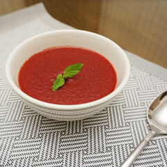 Red colored borscht served in white bowl