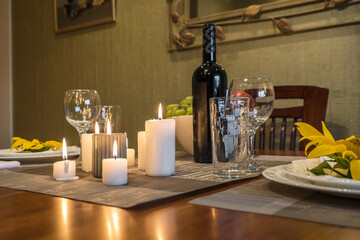 Interior of  kitchen in studio apartments with a served table with wine, fruit and candles