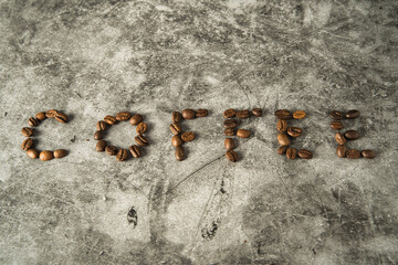 Flat lay of a group of seeds of coffee making letters of coffee word in a surface