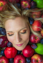 Fototapeta na wymiar Portrait, head of young beauty caucasian woman with blonde hair and closed eye in fruit background. Health eating, diet, cosmetics concept