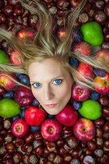 Fototapeta na wymiar Portrait, head of young beauty caucasian woman with blonde hair looking from fruit and chestnut background. Health eating, diet, cosmetics concept