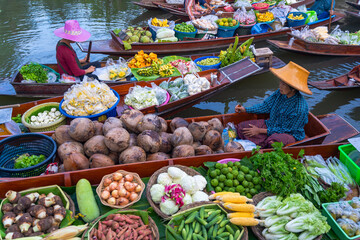 Damnoen Saduak Floating Market tourists visiting by boat popular attractions on canals of Ratchaburi, Thailand.