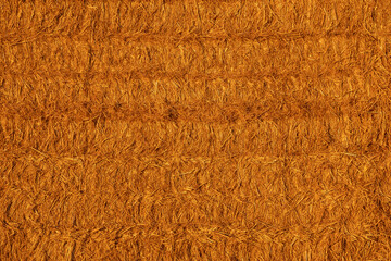 Texture of stacked straw bales in warm light