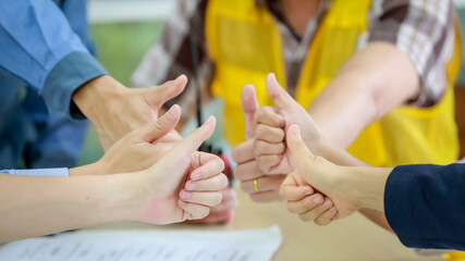 Close up shot of hands sign of professional male female unidentified unrecognizable architecture and engineer worker team shows thumbs up together as teamwork, successful business agreement approval