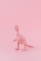 Pink painted Dinosaur rex isolated on pink pastel background. Minimal Monochromatic creative concept with copy space.
