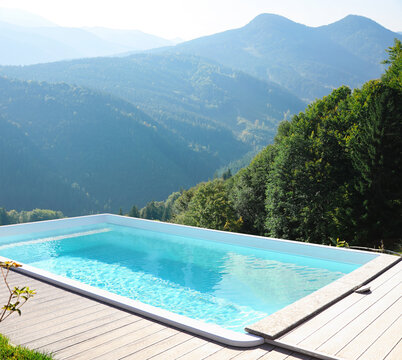 Outdoor swimming pool at luxury resort and beautiful view of mountains on sunny day