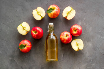Homemade apple cider vinegar in glass bottle with red apples