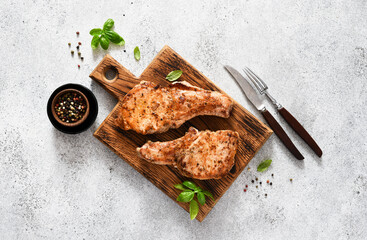 Two fried pork steaks with spices on a mesotm wood board under the text - 461659702