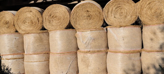Fresh bales of hay lie in a warehouse 