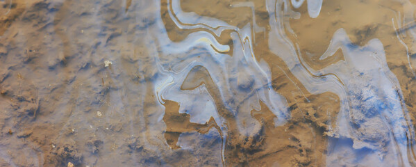 puddle gasoline background, wet oil multicolored rainbow pollution spill