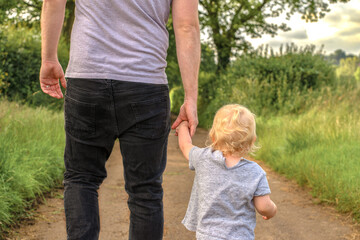 father and daughter, son walking in park holding hands. family concept