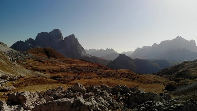 Croda Del Lago Circuit, Dolomites, South Tyrol, Northern Italy.  Drone shot over an expansive lush autumn day landscape. with sharp peaks in the background.