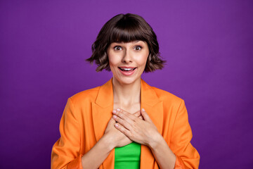 Photo of sincere young brunette lady hands heart wear orange blazer top isolated on violet color...