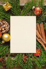Obraz premium Christmas Composition with a blank card, fir branches and decorations on wooden table
