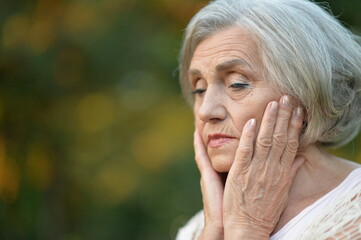 sad senior woman in  park