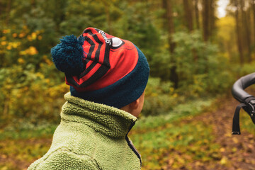 Boy in red Spider-Man beanie walking in a forest in the autumn © StellaSalander