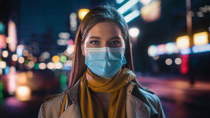 Portrait of a Beautiful Woman Wearing a Protective Face Mask in Trench Coat Standing in a Modern...