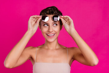 Photo of dreamy charming happy cheerful young lady look curious empty space isolated on magenta color background