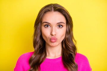 Fototapeta premium Photo of pretty flirty curly young lady dressed pink pullover sending kiss lips pouted isolated yellow color background