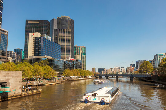 Sightseeing river cruising boats on Yarra River in city centre of Melbourne.