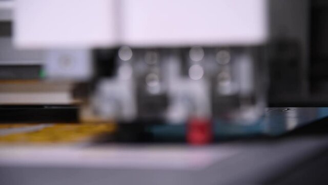 Industrial A close-up of an industrial plotter cuts a template on a cardboard packaging for products. real time shallow depth of field. Live camera
