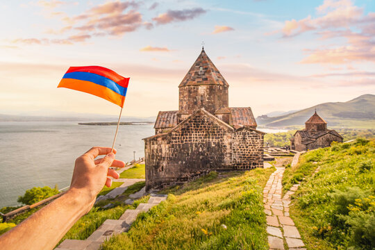 Armenian flag and famous Sevanavank Monastery on the shore of Lake Sevan. Travel landmarks and national patriotism concept