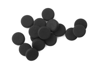 Activated charcoal pills on white background, top view. Potent sorbent