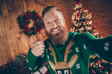 Self-portrait of attractive cheerful guy having fun showing thumbup eve day at modern loft industrial style indoors