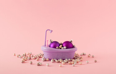 Creative layout made of Christmas balls in pearl bath isolated on pink background. MInimal fashion , winter, Christmas or New Year party concept art. Copy space.