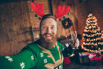 Self-portrait of attractive cheerful funky guy drinking champagne having fun eve day at modern loft industrial style indoors