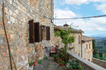 Fototapeta na wymiar Haus mit kleiner Terrasse in der Altstadt von San Gimignano mit Ausblick auf Toskana Landschaft