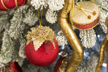 Close up of holidays location with red gold toys, garlands and drum on Christmas tree