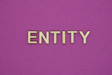  word entity in small square wooden letters on a lilac background