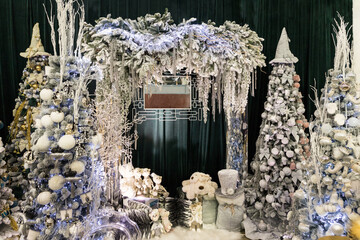 Holidays photozone with Christmas trees and toys in white and blue colors