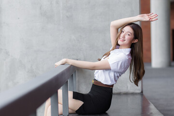 Portrait of adult Thai student in university student uniform. Asian beautiful girl sitting smiling...