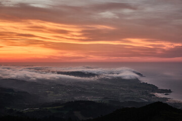 Clouds descend over Playa de la Isla at sunset. Asturias. Spain