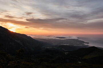 Fototapeta na wymiar Clouds descend over Playa de la Isla at sunset. Asturias. Spain