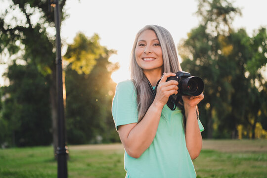 Portrait of attractive cheerful grey-haired woman spending time making capture art snap landscape evening sunset outdoors - Powered by Adobe