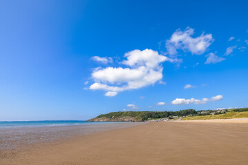 An idyllic beach setting with deep blue seas and bright blue sky