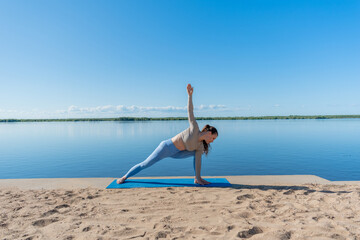 Diversity red hair woman doing yoga outdoors in the park. Sportswear and yoga mat. Copy space