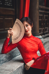 woman in a red traditional ao dai dress