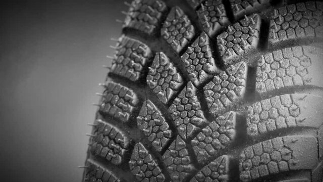 Super slow motion of falling snow on tire sample, close-up, free space for text. Filmed on high speed cinema camera, 1000 fps.