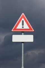 A sign with a exclamation mark warning for a dangerous situation ahead and a smaller sign below with space for an editor to place own text