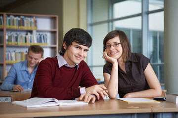 Obraz premium Portrait of smiling students at desk in library