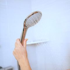 a shower can in a woman's hand. plumbing for the bathroom. 