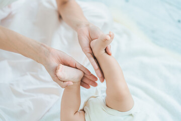赤ちゃんの足を支えるお母さんの手