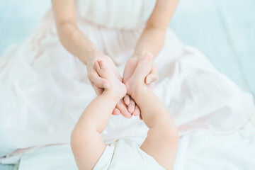 Fototapeta na wymiar 赤ちゃんの足を支えるお母さんの手